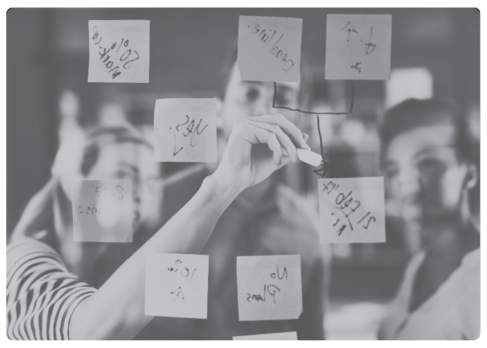 innovation sandbox card blurry people drawing on sticky notes attached to a clear board